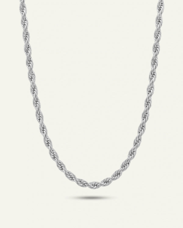 A silver-toned braided chain necklace with a polished finish, displayed in a U-shape against a clean white background with a subtle reflection below.