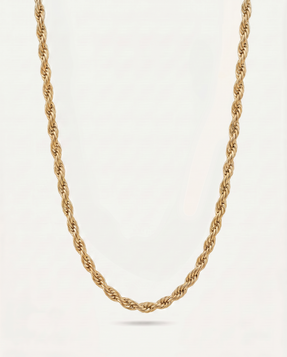 A gold rope chain necklace displayed against a clean, off-white background.