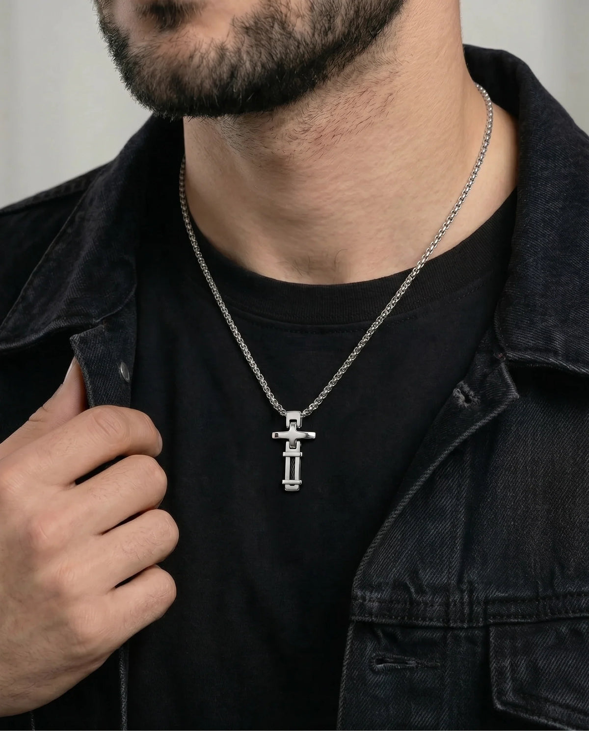 Close-up of stainless steel cable cross pendant