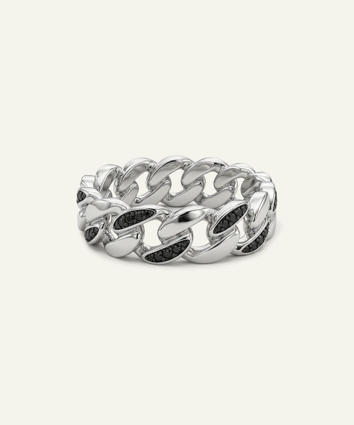 A men's silver Cuban link band ring set with black round-cut gemstones on a light cream background.