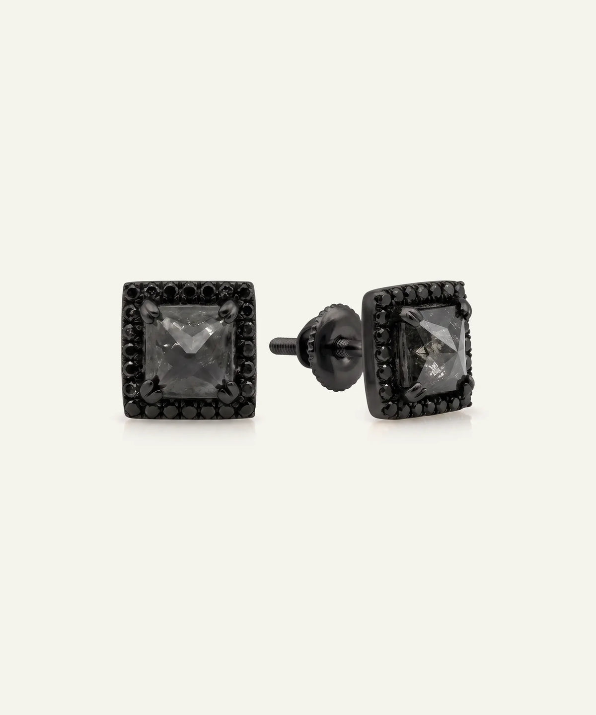 Close-up of men's princess-cut black diamond halo stud earrings