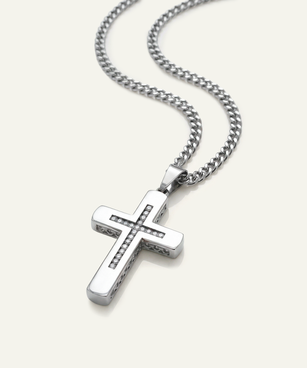 Silver cross pendant on a chain against a white background