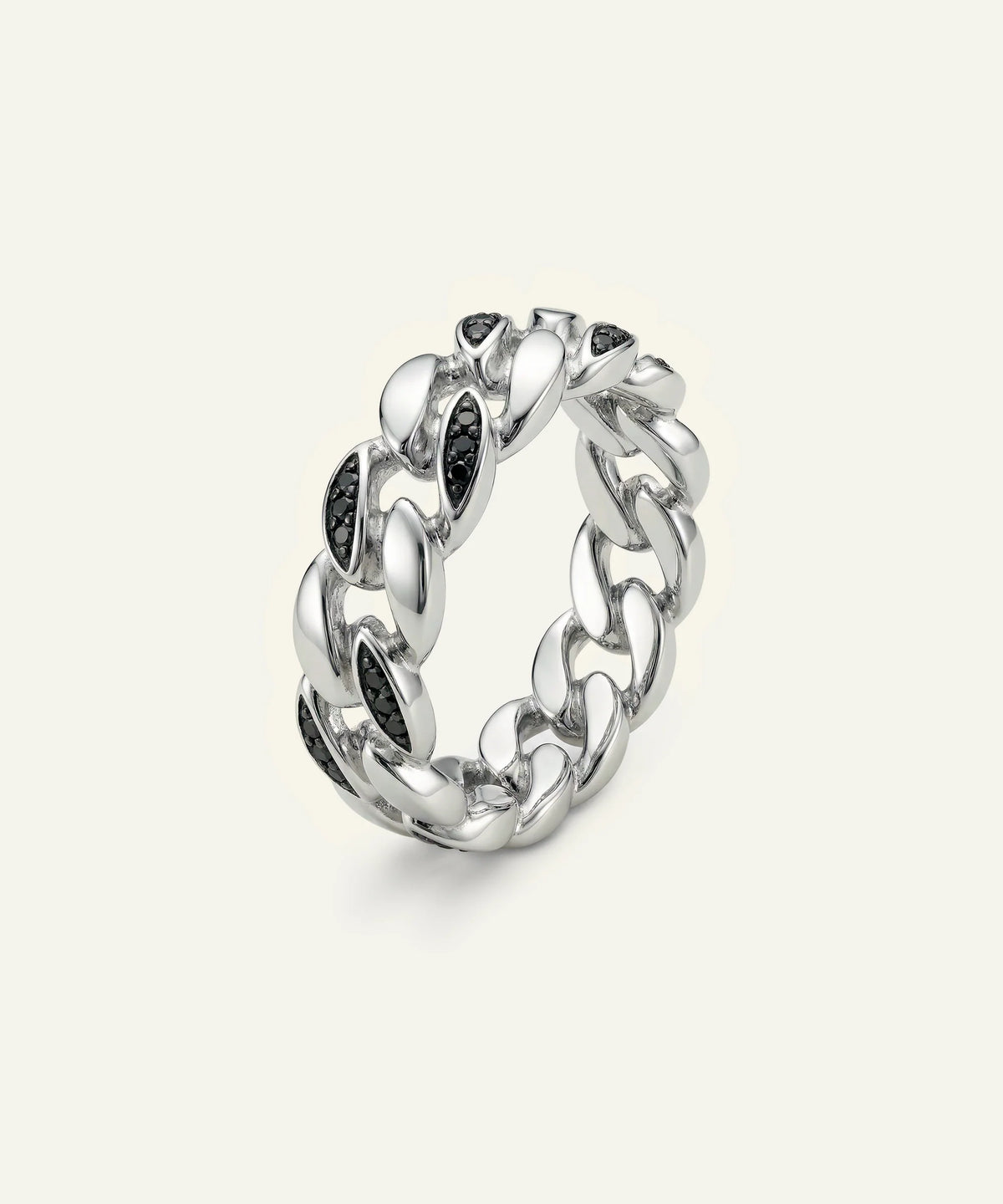 A men's silver Cuban link band ring set with black round-cut gemstones on a light cream background.