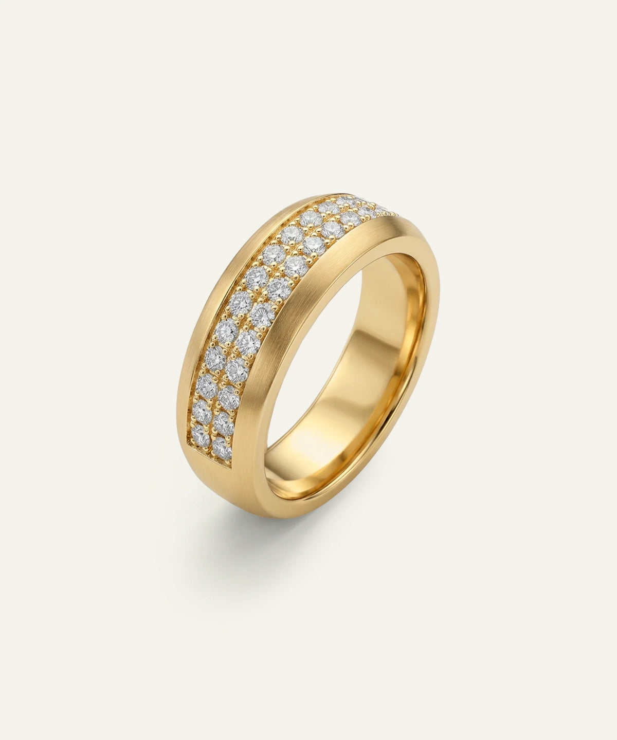 A men's wide yellow gold two-row diamond band ring on a light cream background.